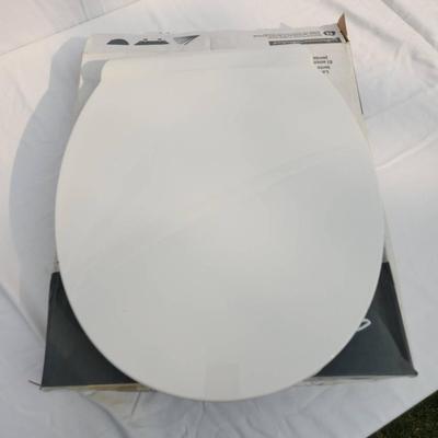 Sale Photo Thumbnail #56: American Standard round front toilet seat in white, featuring slow-close technology for noiseless closure. Made of durable plastic with easy-to-clean surfaces. Designed for round front toilets, it includes secure mounting hardware and a sanitary lift tab 
