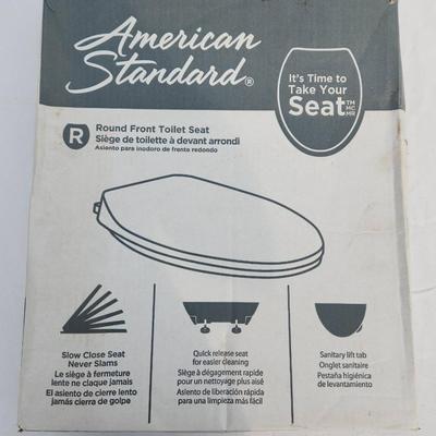 Sale Photo Thumbnail #55: American Standard round front toilet seat in white, featuring slow-close technology for noiseless closure. Made of durable plastic with easy-to-clean surfaces. Designed for round front toilets, it includes secure mounting hardware and a sanitary lift tab 