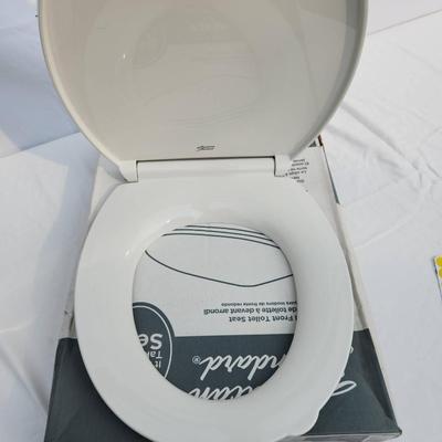 Sale Photo Thumbnail #57: American Standard round front toilet seat in white, featuring slow-close technology for noiseless closure. Made of durable plastic with easy-to-clean surfaces. Designed for round front toilets, it includes secure mounting hardware and a sanitary lift tab 