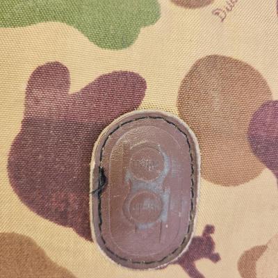 Sale Photo Thumbnail #74: Canvas rifle case featuring a camouflage pattern with leather reinforcement accents. Includes dual carrying handles for convenience and a zipper closure system. Interior is lightly padded with signs of wear, including discoloration and potential stains. E