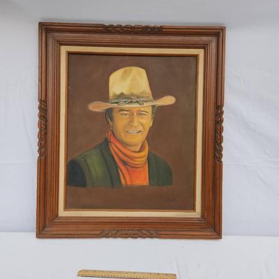 Sale Photo Thumbnail #90: Framed portrait painting depicting a cowboy wearing a tan hat, red scarf, and dark vest. Signed by the artist 'Janet' on the lower right corner. The painting is done on canvas and is framed in a decorative wooden frame with a carved design. Back of the fr