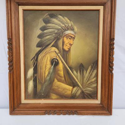 Sale Photo Thumbnail #93: Framed oil painting on canvas depicting a Native American chief in traditional headdress. The frame, crafted from carved wood with decorative elements, appears to complement the artwork. Reverse side shows dimensions marked as 20x24 inches and a faded sta