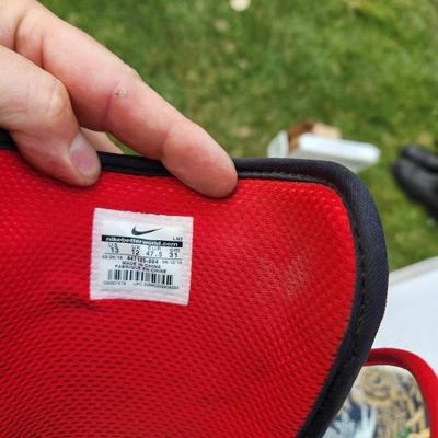 Sale Photo Thumbnail #99: Ride snowboard featuring bold red and black graphics on both sides. Comes equipped with Nike SB Vapen snowboard boots in red and black colorway, size 13 (US), and matching bindings. The snowboard showcases an intricate skull and rose design on one side an
