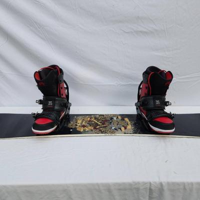 Sale Photo Thumbnail #96: Ride snowboard featuring bold red and black graphics on both sides. Comes equipped with Nike SB Vapen snowboard boots in red and black colorway, size 13 (US), and matching bindings. The snowboard showcases an intricate skull and rose design on one side an