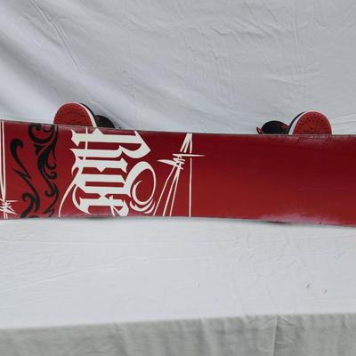Sale Photo Thumbnail #100: Ride snowboard featuring bold red and black graphics on both sides. Comes equipped with Nike SB Vapen snowboard boots in red and black colorway, size 13 (US), and matching bindings. The snowboard showcases an intricate skull and rose design on one side an