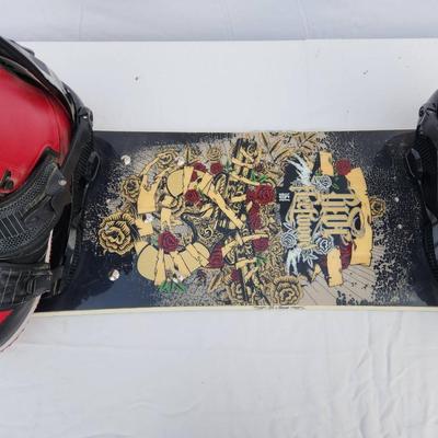 Sale Photo Thumbnail #97: Ride snowboard featuring bold red and black graphics on both sides. Comes equipped with Nike SB Vapen snowboard boots in red and black colorway, size 13 (US), and matching bindings. The snowboard showcases an intricate skull and rose design on one side an