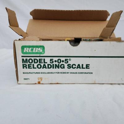 Sale Photo Thumbnail #101: RCBS Model 5-0-5 Reloading Scale by Ohaus Corporation. The lot includes the original packaging and components visible within the box. Designed for precision reloading, ensuring accurate weight measurements. Used condition with possible signs of prior use.