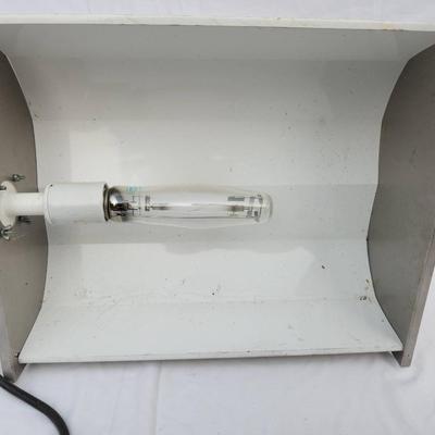 Sale Photo Thumbnail #106: Metal halide light fixture featuring a metal reflector housing, an integrated ballast unit, and a clear bulb installed. The ballast casing is white with visible signs of wear, and labeled with operational specifications. The unit includes wired connection