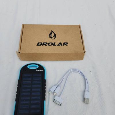 Sale Photo Thumbnail #110: Brolar solar-powered power bank featuring a built-in solar panel for charging, along with a USB cable and a lightning/30-pin adapter cable. The package includes the original branded box. Suitable for charging electronic devices. Condition appears to be un