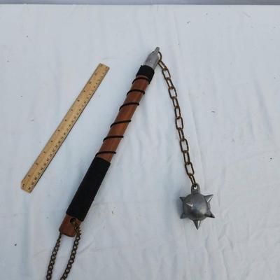 Sale Photo Thumbnail #111: Medieval-style flail featuring a spiked metal ball connected to a chain and a leather-wrapped handle for grip. The flail includes a chain loop at the end of the handle for hanging or securing. The spiked ball and chain appear to be metal, with the handle 