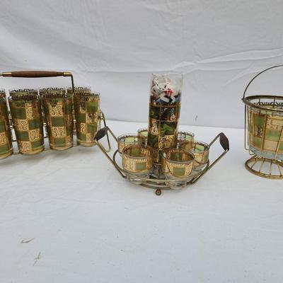 Sale Photo Thumbnail #114: Mid-century drinkware set featuring green and gold checkered glass designs. The set includes a group of tall glasses in a brass wire carrier with a wooden handle, a smaller set of lowball glasses in a brass carrier with wooden handles, and an additional i
