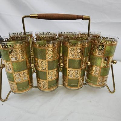 Sale Photo Thumbnail #115: Mid-century drinkware set featuring green and gold checkered glass designs. The set includes a group of tall glasses in a brass wire carrier with a wooden handle, a smaller set of lowball glasses in a brass carrier with wooden handles, and an additional i