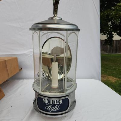 Sale Photo Thumbnail #124: Michelob Light promotional hanging lantern-style light featuring a chrome body with glass panels, an internal candle-shaped bulb, and branded 'Michelob Light' signage. Includes original packaging. Designed as a decorative electric light fixture. In good c