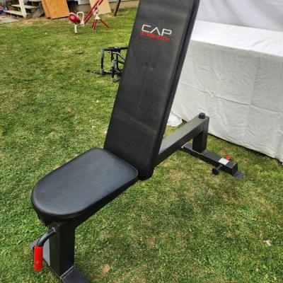 Sale Photo Thumbnail #128: CAP Strength adjustable weight bench with a durable padded seat and backrest for comfortable support during workouts. Features a sturdy steel frame with a black finish, red accents, and non-slip foot caps for stability. Designed for various incline, flat,
