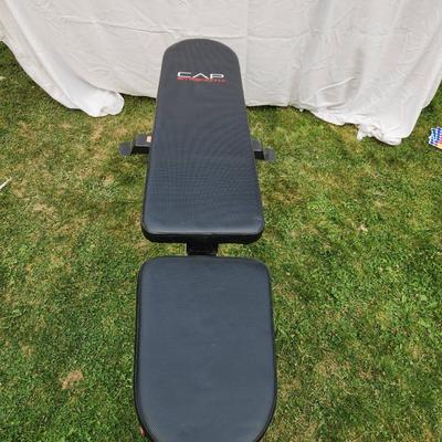 Sale Photo Thumbnail #126: CAP Strength adjustable weight bench with a durable padded seat and backrest for comfortable support during workouts. Features a sturdy steel frame with a black finish, red accents, and non-slip foot caps for stability. Designed for various incline, flat,