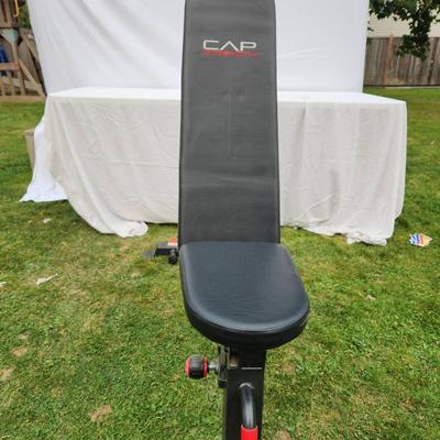 Sale Photo Thumbnail #127: CAP Strength adjustable weight bench with a durable padded seat and backrest for comfortable support during workouts. Features a sturdy steel frame with a black finish, red accents, and non-slip foot caps for stability. Designed for various incline, flat,