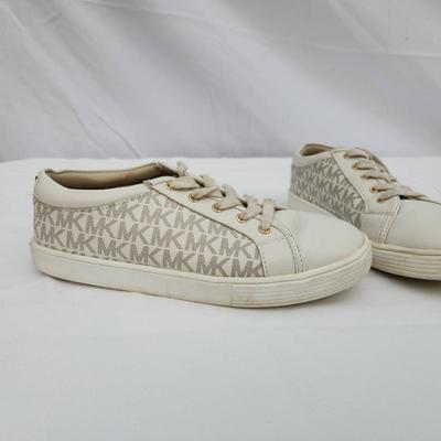 Sale Photo Thumbnail #129: Michael Kors women's lace-up sneakers with monogram print. Tagged as size US 5.5 (EU 35, UK 3). Features beige canvas and leather with gold-tone eyelets. Moderate wear visible on soles and minor scuffs on toes. Made in China.