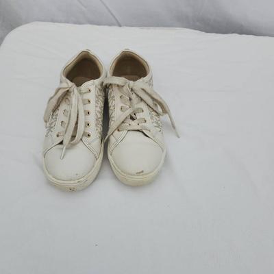 Sale Photo Thumbnail #131: Michael Kors women's lace-up sneakers with monogram print. Tagged as size US 5.5 (EU 35, UK 3). Features beige canvas and leather with gold-tone eyelets. Moderate wear visible on soles and minor scuffs on toes. Made in China.