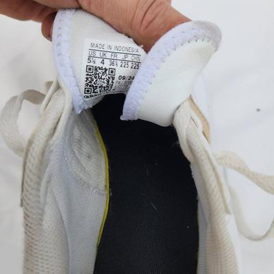 Sale Photo Thumbnail #134: Adidas women's athletic sneakers in white with gold accents. Made in Indonesia, these shoes are labeled as size 5.5 US (EU 36, UK 4, JP 225). Features include a lace-up closure, synthetic materials, and a padded insole for comfort. Good pre-owned conditio