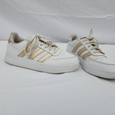 Sale Photo Thumbnail #132: Adidas women's athletic sneakers in white with gold accents. Made in Indonesia, these shoes are labeled as size 5.5 US (EU 36, UK 4, JP 225). Features include a lace-up closure, synthetic materials, and a padded insole for comfort. Good pre-owned conditio
