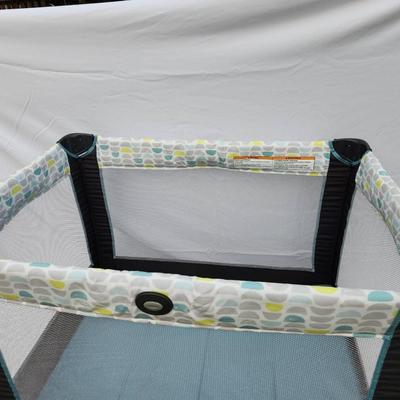 Sale Photo Thumbnail #147: Graco Pack 'n Play portable playard featuring a mesh design for easy ventilation and visibility. Includes a sturdy frame with wheels for easy mobility and a patterned fabric upper section. Comes with a convenient carrying bag for transportation and storag