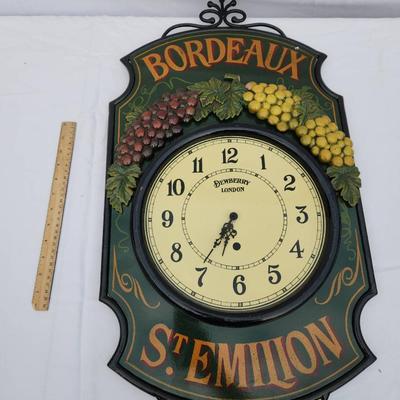 Sale Photo Thumbnail #154: Bordeaux St. Emilion decorative wall clock, featuring a wrought iron frame and a wine-themed design with 3D grape clustering details in red and yellow colors. The clock face displays 'Bordeaux Import' and numbered hours, with hour and minute hands. Measur