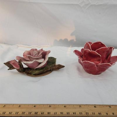 Sale Photo Thumbnail #193: Two ceramic rose figurines, including a pink rose with green leaf details on a base and a red rose with white accent edges. Both are highly detailed. The ruler indicates approximate size, with each piece under 6 inches in width. Condition appears intact w
