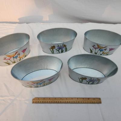 Sale Photo Thumbnail #200: 5 oval-shaped metal planters featuring colorful hand-painted floral designs accented with butterflies and bees. Each planter is approximately 10 inches wide, as indicated by the ruler in the image. These lightweight planters are ideal for indoor or outdoo