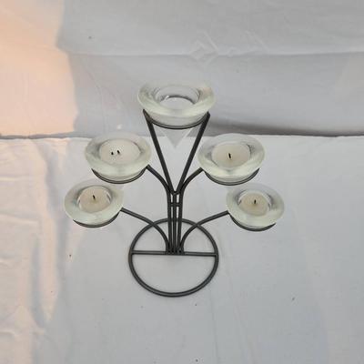 Sale Photo Thumbnail #203: Metal candle holder featuring five frosted glass votive cups arranged in a tiered design. The sturdy metal frame has a circular base and branched arms holding each votive. Includes a measurement scale in the image for size reference. Condition shows minor