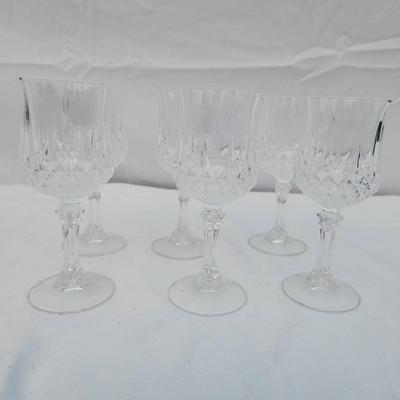 Sale Photo Thumbnail #244: 6 crystal wine glasses crafted with an intricate carved design, featuring faceted bowls and ornate stems. Condition is excellent with no visible chips, cracks, or clouding. These glasses are suitable for formal settings or decorative purposes. Dimensions 