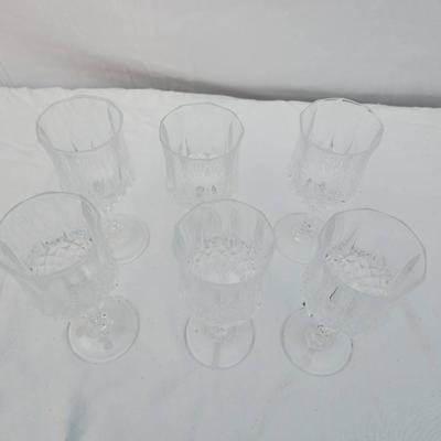 Sale Photo Thumbnail #246: 6 crystal wine glasses crafted with an intricate carved design, featuring faceted bowls and ornate stems. Condition is excellent with no visible chips, cracks, or clouding. These glasses are suitable for formal settings or decorative purposes. Dimensions 