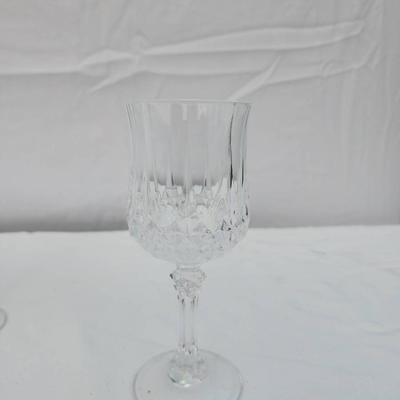 Sale Photo Thumbnail #245: 6 crystal wine glasses crafted with an intricate carved design, featuring faceted bowls and ornate stems. Condition is excellent with no visible chips, cracks, or clouding. These glasses are suitable for formal settings or decorative purposes. Dimensions 