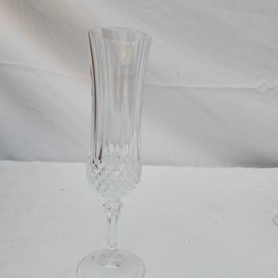 Sale Photo Thumbnail #248: Eight clear crystal champagne flute glasses with intricate cut designs on the stems and faceted detailing. Each flute features an elegant, elongated bowl ideal for serving champagne or sparkling wines. Condition appears to be good with no visible chips or