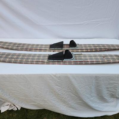 Sale Photo Thumbnail #259: Vintage water skis crafted from wood, featuring a distinctive plaid pattern on the surface. The skis are equipped with metal bindings and black foot straps. Visible wear is present, including scratches and marks consistent with use and age. The underside 