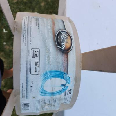 Sale Photo Thumbnail #265: Plastic lawn edging installation tool designed for securing lawn borders. Features a wooden handle and a plastic attachment for aligning and situating lawn edging materials. Label indicates compatibility with specific plastic lawn edging products. Appears