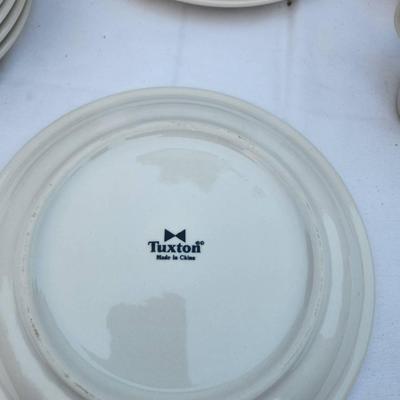 Sale Photo Thumbnail #282: 22 white ceramic items, including 15 rounded, stackable plates, 7 saucers, and 4 matching coffee cups with handles. Designed for durability and frequent use, suitable for both commercial and home settings. Uniform in design for seamless coordination.