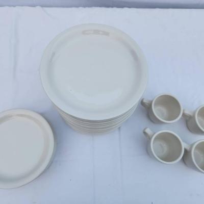 Sale Photo Thumbnail #284: 15 white ceramic restaurant-style plates, 7 matching saucers, and 4 handle-equipped coffee cups. All items are crafted for durability and are stackable, making them ideal for both commercial and home use. Uniform design ensures a cohesive look throughout 