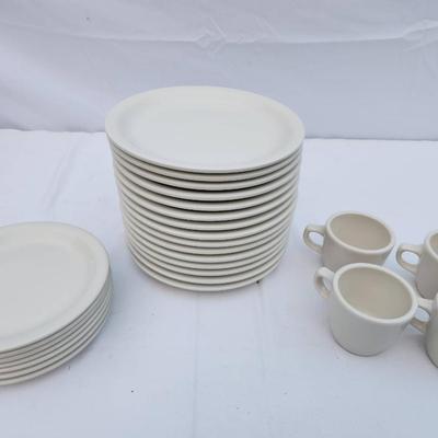 Sale Photo Thumbnail #289: 15 white ceramic restaurant-style plates, 7 white saucers, and 4 matching ceramic coffee cups. Plates and saucers are rounded and stackable, crafted for durability and regular use. Coffee cups are equipped with handles for an easy grip. Uniform design mak