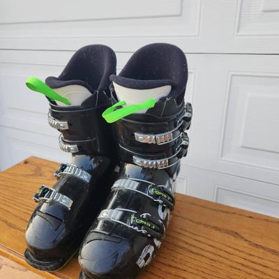 Sale Photo Thumbnail #292: Rossignol Comp J4 Ski Boots featuring a black and green design, four adjustable buckles for secure fit, and comfort-focused padding. The sole length is marked as 295 mm. Designed for junior skiers, these boots combine performance and ease of use. Pre-owne