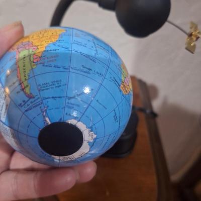 small desk globe that is suspended between magnets