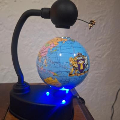 small desk globe that is suspended between magnets
