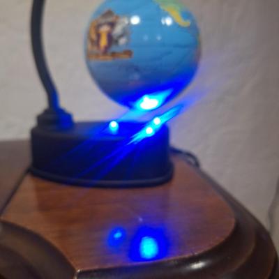 small desk globe that is suspended between magnets