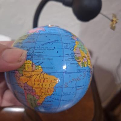 small desk globe that is suspended between magnets