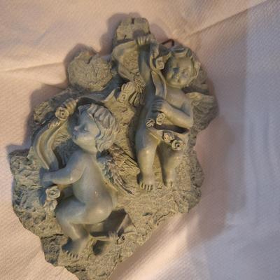 plaster or other material wall hanging with cherubs