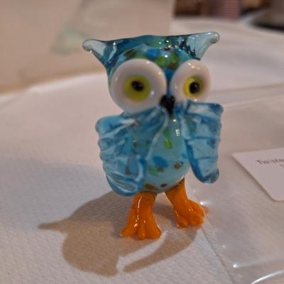 miniature glass owl, wings covering mouth