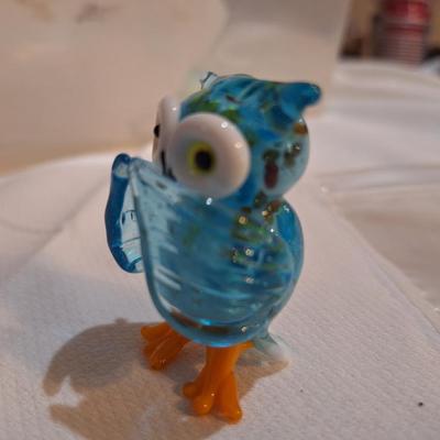 miniature glass owl, wings covering mouth
