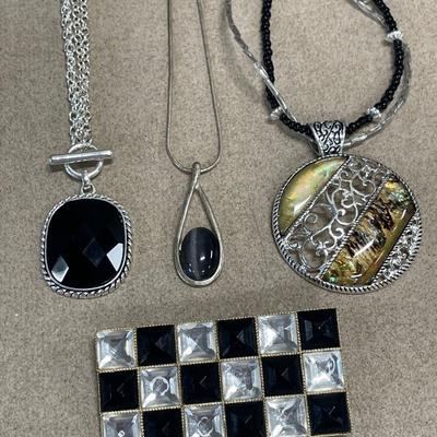 Large pendant necklaces and black and clear checkered brooch