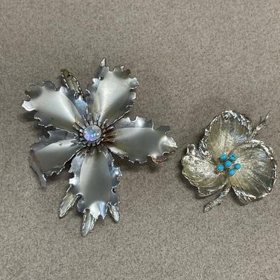 Larger hibiscus Aurora Borealis brooch and smaller leaf brooch with blue decor
