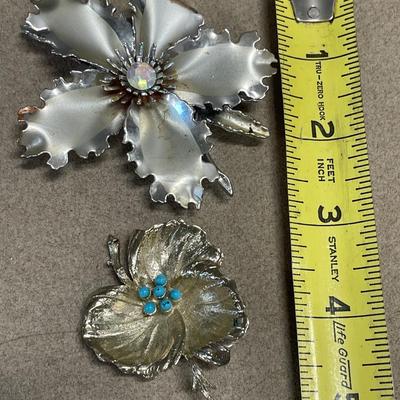 Larger hibiscus Aurora Borealis brooch and smaller leaf brooch with blue decor
