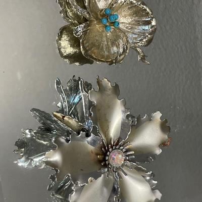 Larger hibiscus Aurora Borealis brooch and smaller leaf brooch with blue decor